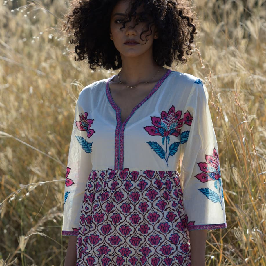 Woman wearing a white dress with floral patterns in a field